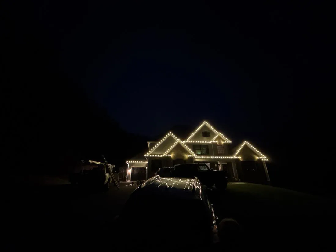 Palmyra, VA home at night with warm white lights following the rooflines