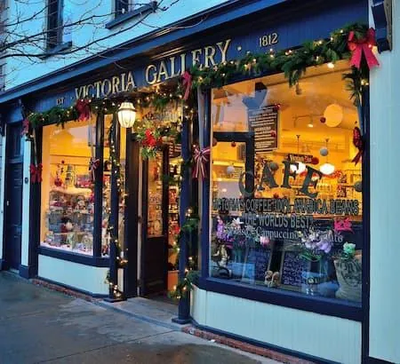 Storefront decorated with garland, red bows and warm white lights